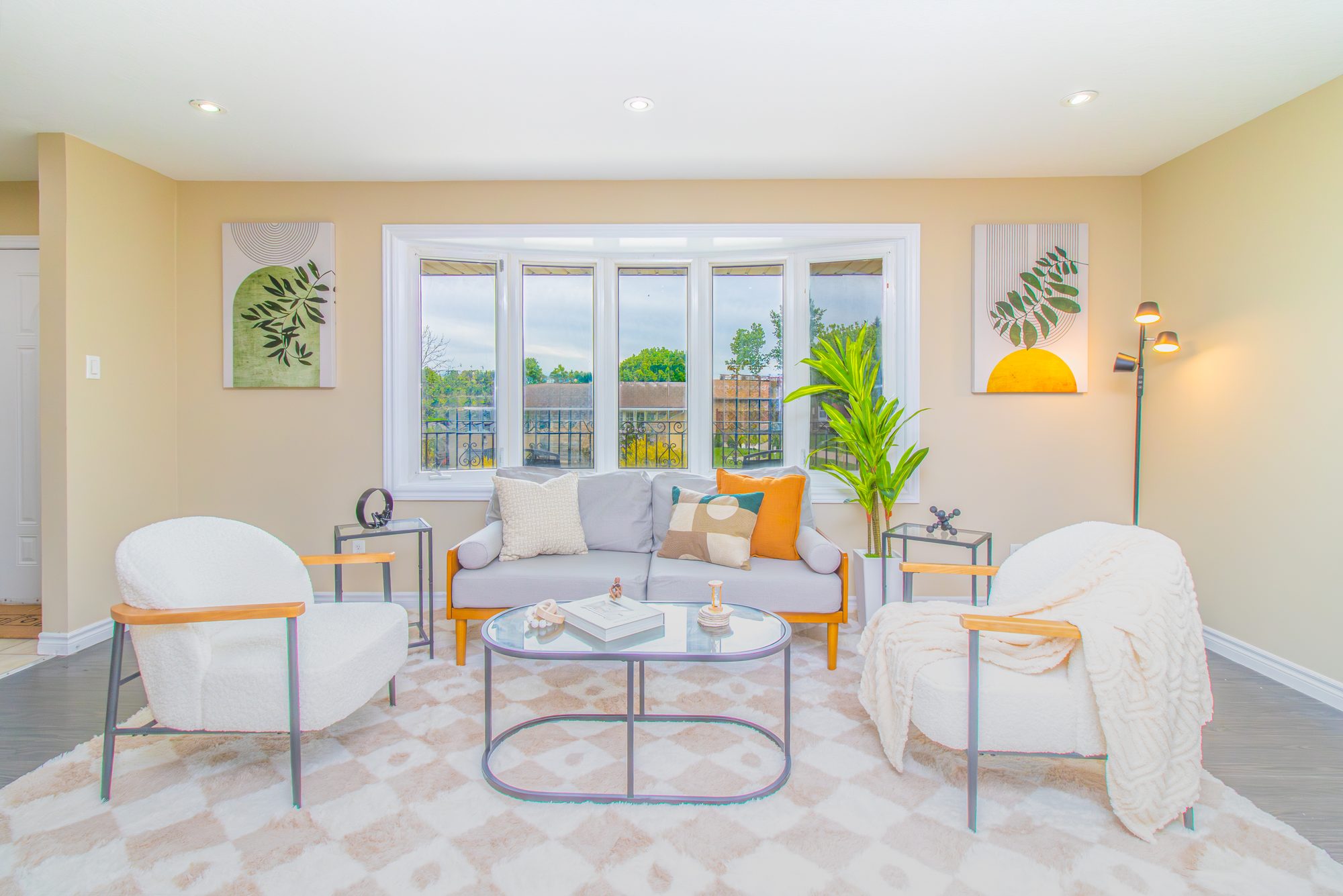 Bright HDR-photographed living room with a large bay window and natural light