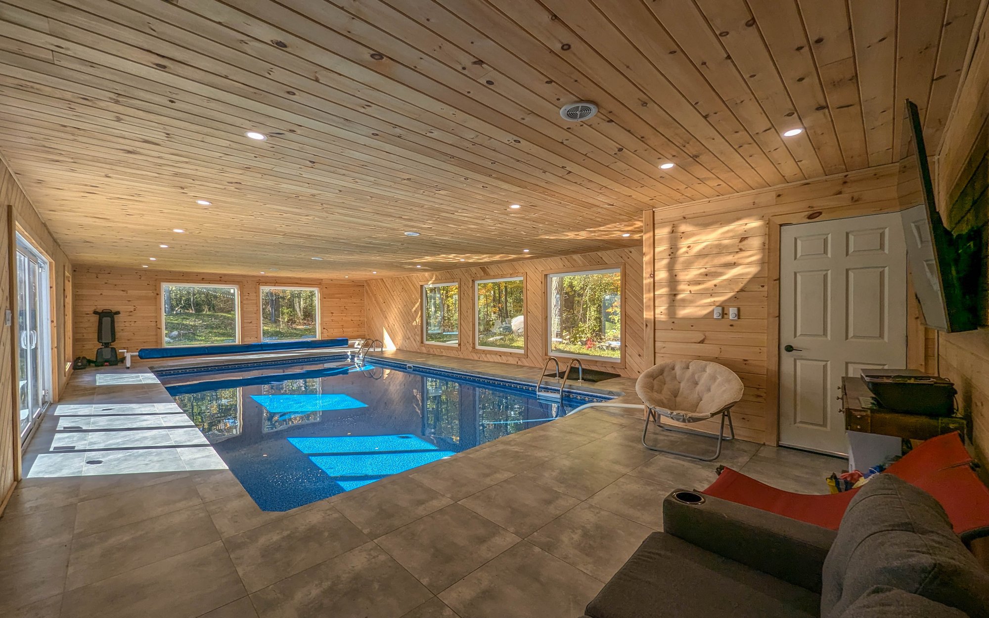 Indoor pool with cedar ceiling and large windows
