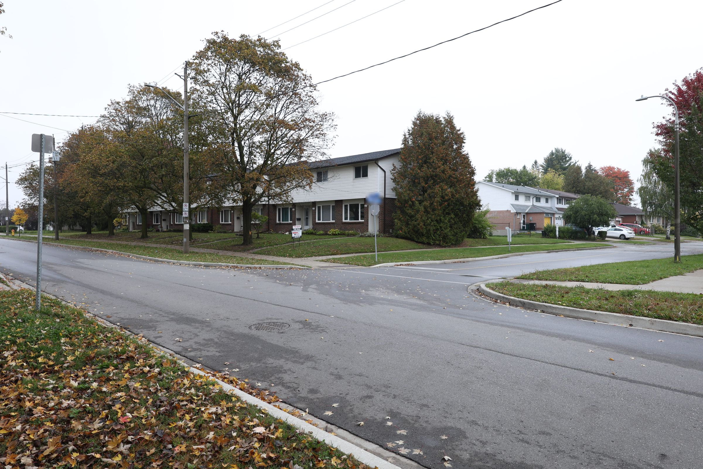 Kitchener townhomes under a flat grey sky, before sky replacement